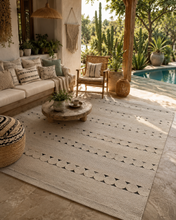 Load image into Gallery viewer, Sahara braided jute rug styled on a sunlit patio
